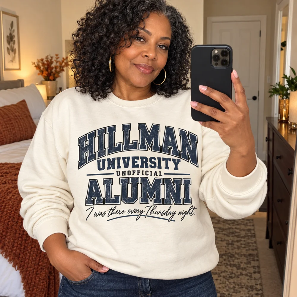 Hillman University Unofficial Alumni charcoal navy design on a cream sweatshirt, mirror selfie